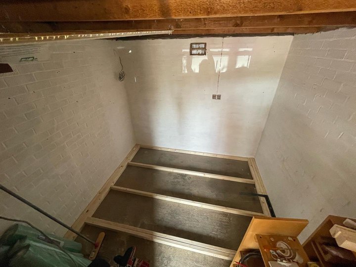 Laid out and screwed together framing timber on the floor of the garage, ready to be insulated.
